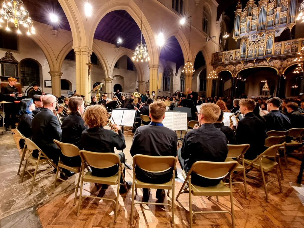 Photo of a wind band performing at the front of a church