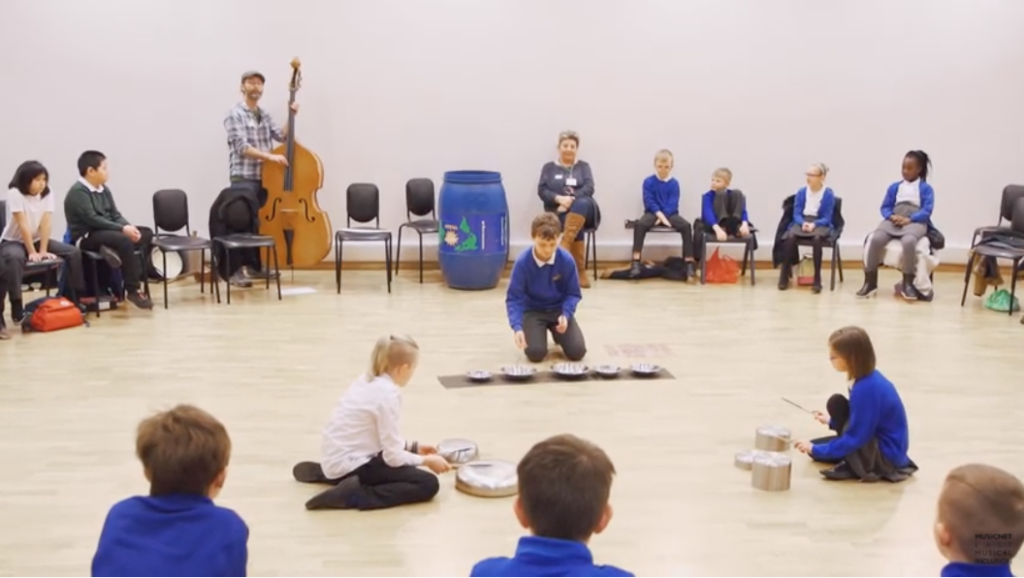 A group of children playing instruments in a hall