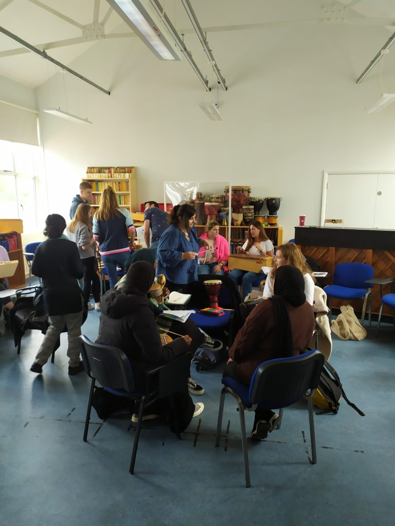 A group of adults sat in a circle in a classroom