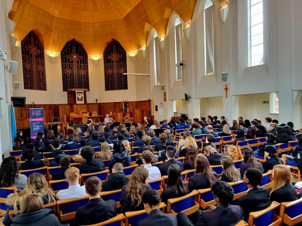 Young people are watching musicians perform in a church.