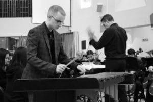 Musician playing the xylophone with a youth orchestra.