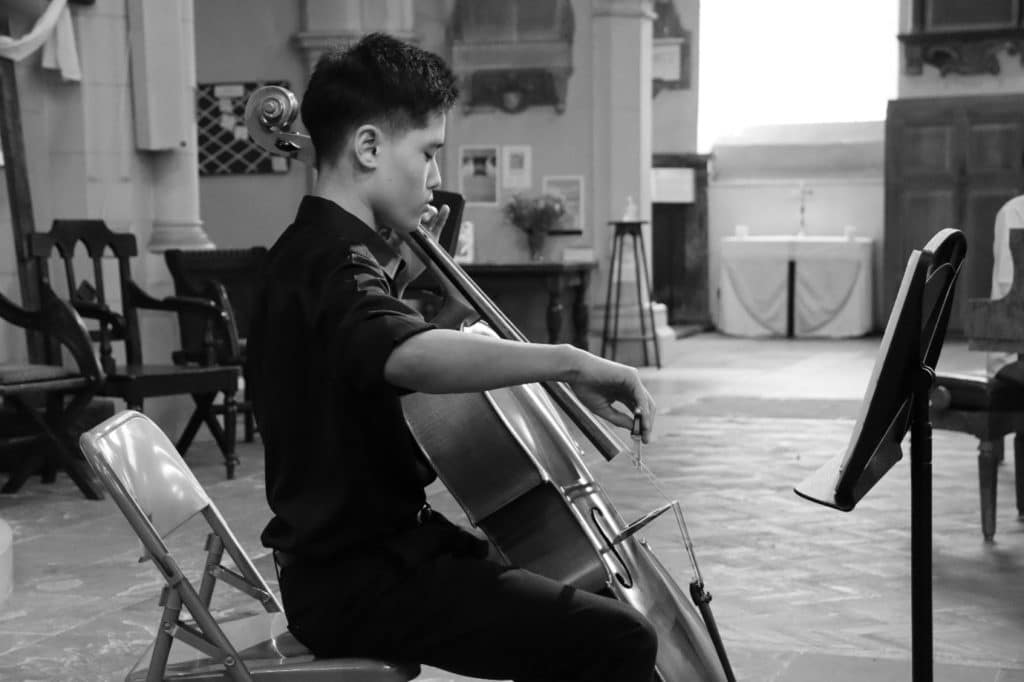 Young person performing on the cello