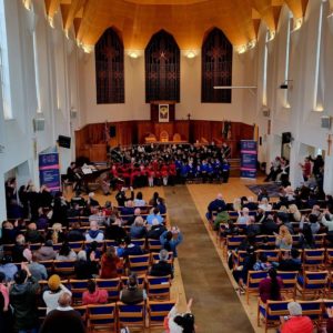 Church with audience watch a massed choir of KS1 pupils singing