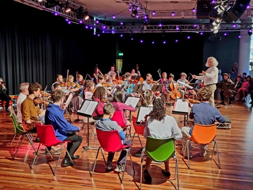 Young musicians reading sheet music on music stands.