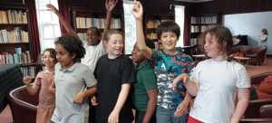 A group of children smiling and posing in a rehearsal