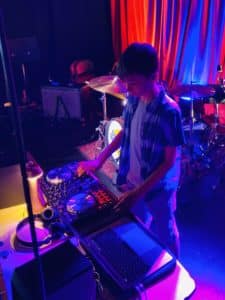 Image of a boy performing on DJ decks on stage