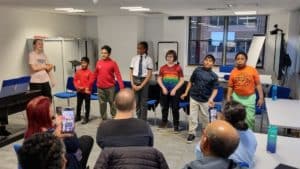 A group of children performing in a large meeting room
