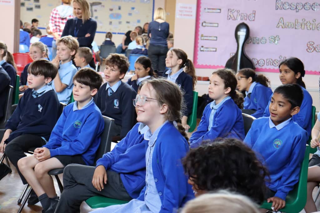A group of students participating in a workshop in a school hall
