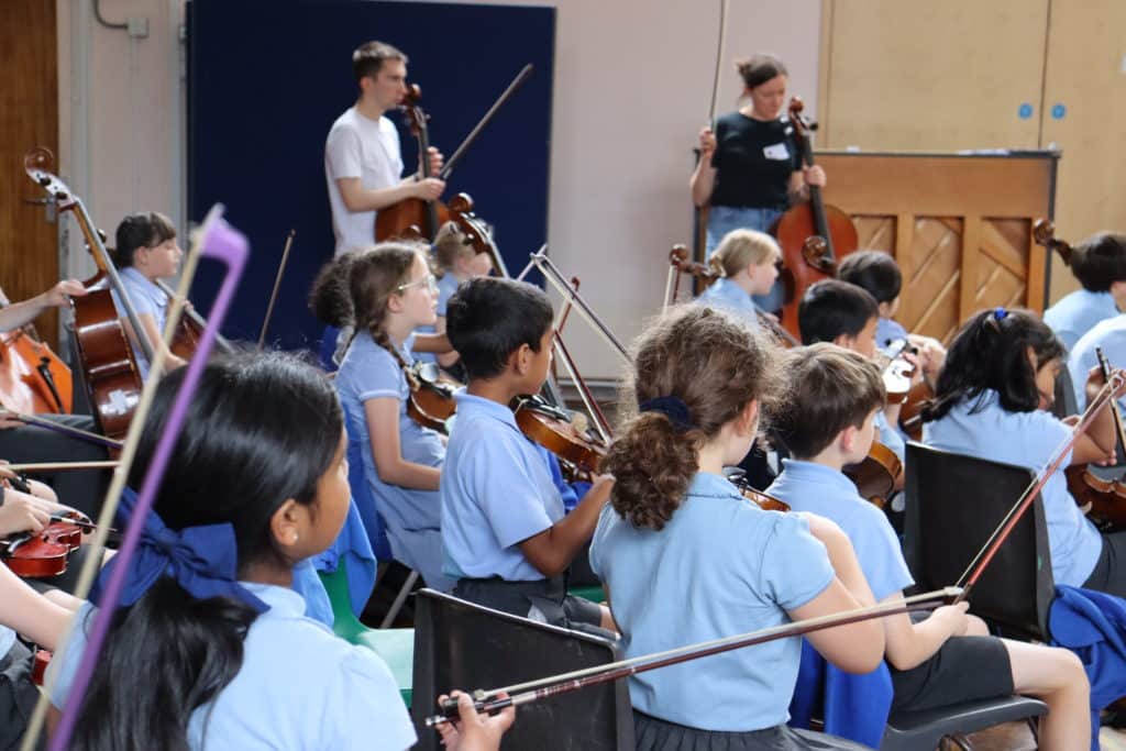 A group of students participating in a workshop in a school hall