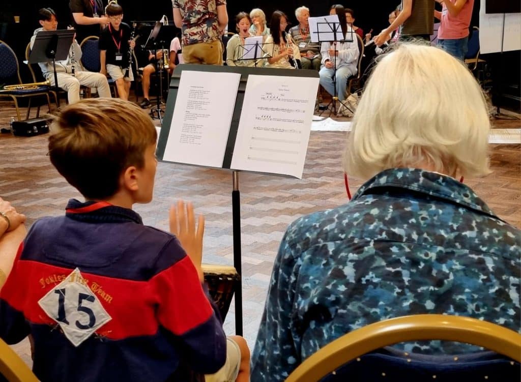 a student an older person playing the Djembe drums