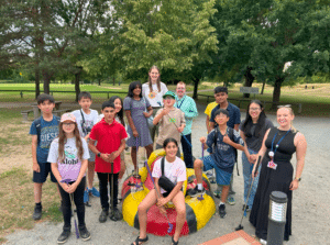 A group of students and 2 adults posing at a mini golf course