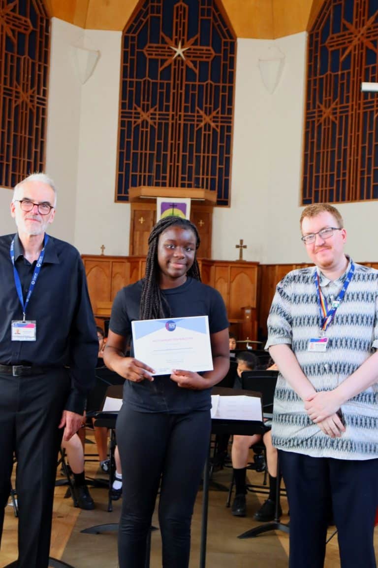 A student and conductor pose with a certificate