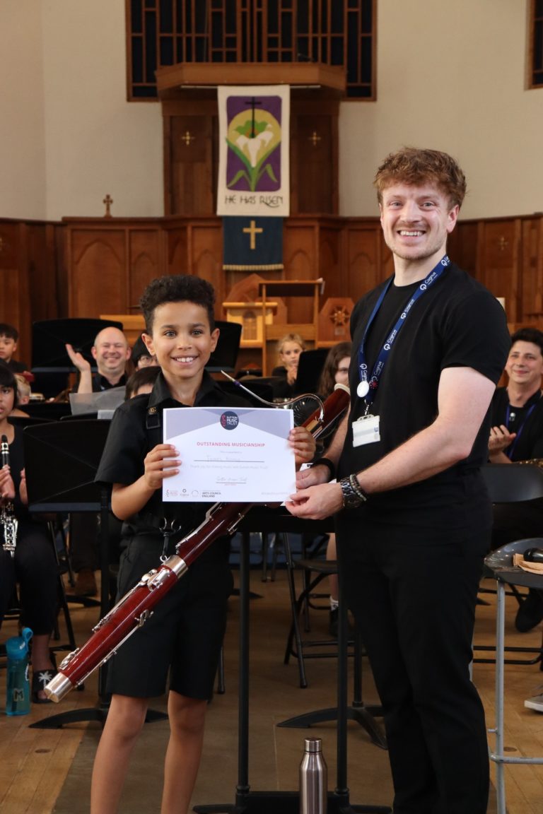A student and conductor pose with a certificate