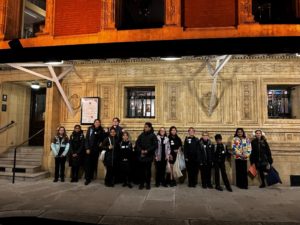Group of students dressed in black pose outside the Royal Albert Hall
