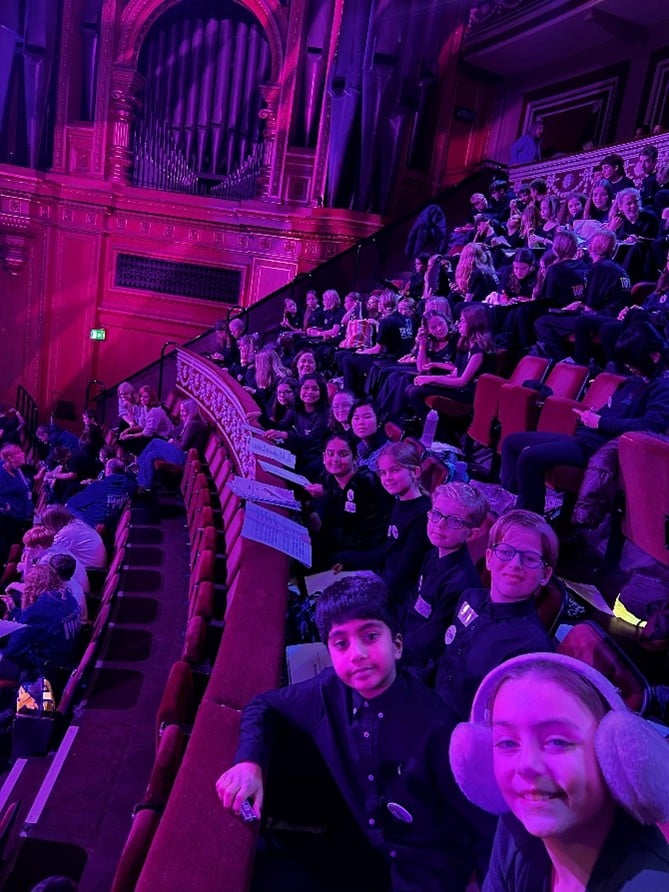 Picture of a group of children sitting in velvet red seats at the Royal Albert Hall