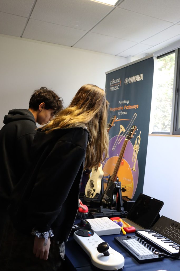 2 students look at musical instruments set up on a table